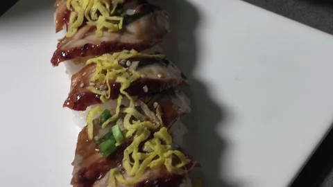 Eel sushi with egg garnish on top. Stock Footage 297166524