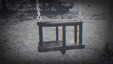 Eerie empty swing moving without nobody sitting on it. Video stock 289073836