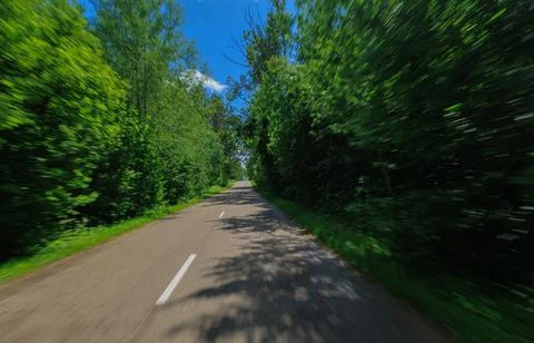 The effect of speed on the road and blurred objects. View of the road. Stock Photos
