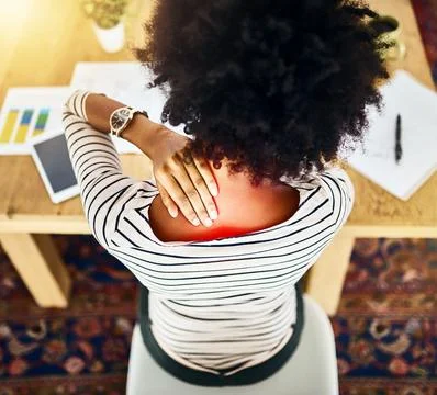 The effects of sitting for too long. Rearview shot of a unrecognizable woman Stock Photos