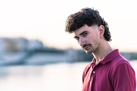 Effeminate young man looking to the camera with serious expression outdoors Stock Photos