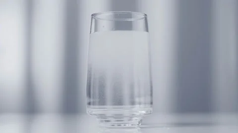 Effervescent aspirin tablet dissolves in a glass of water. Stock Footage 163412688