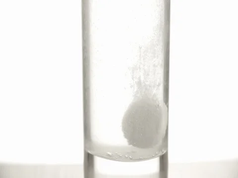 Effervescent aspirin tablet dropping glass water 4k fizzy pill video. Close up Stock Footage 83931884