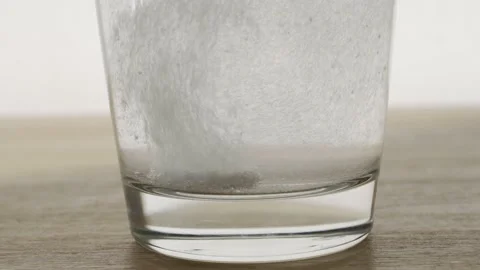 Effervescent dissolving fizzy tablet in water glass Stock Footage 150675621
