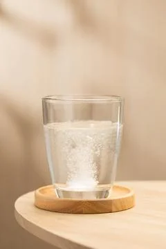 Effervescent mucolytic tablet dissolves in water. Stock Photos