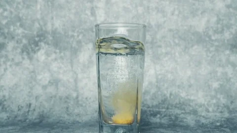 Effervescent or carbon tablet dropped and dissolved in a glass of water Stock Footage 209254490