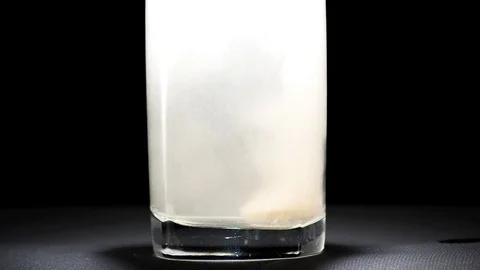 Effervescent pill dropping into a glass of water. Stock Footage 72894295