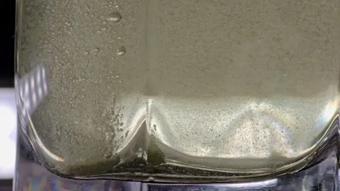 Effervescent, soluble tablet falling into glass of water, close-up Stock Footage 296019029