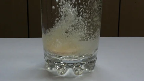 Effervescent tablet bubbles in glass of water Vídeos de archivo 116170159