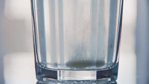 Effervescent Tablet Creating Bubbles in Glass of Water Vidéo 332890090