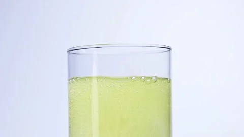 Effervescent tablet dissolves in a glass of water slow mo Stock Footage 147458982