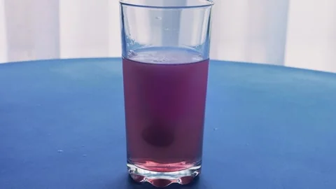 An effervescent tablet dissolves in a glass of water  Stock Footage 285652516