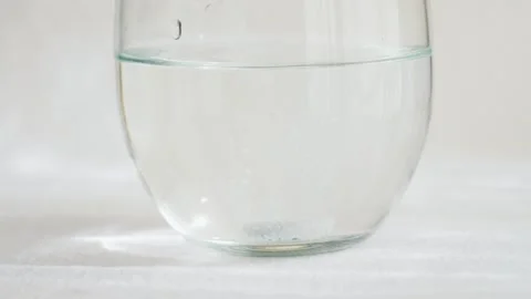 The effervescent tablet dissolves in a glass of water. Stock Footage 327845836