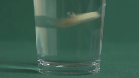 Effervescent tablet dissolving in the glass of water. Slow motion. Stock Footage 119121376