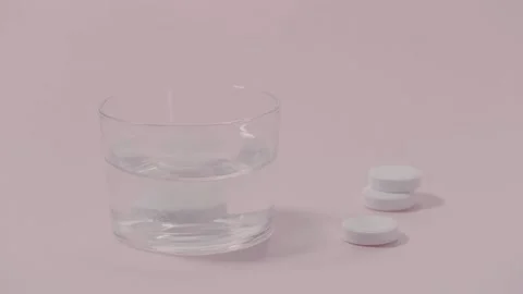 Effervescent tablet dissolving in glass water.   Stock Footage 142096704