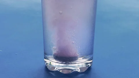 Effervescent tablet dissolving in a glass of water, large bubbles. Medium sho Stock Footage 288737915