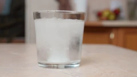 Effervescent tablet dissolving in a glass of water Stock Footage 329104244