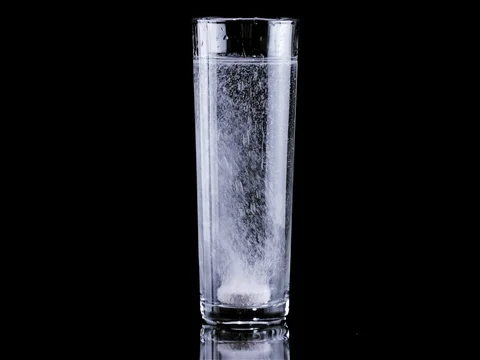 Effervescent tablet falling in full glass of water Stock Footage 81181610