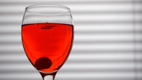 Effervescent Tablet Falling Into Glass of Red Wine and Dissolving Video stock 104618291