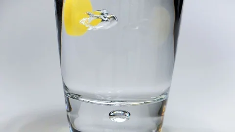 Effervescent tablet falling into glass of water Stock Footage 101059896