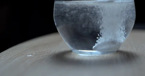 Effervescent tablet falling in water glass slowmotion 4K Stock Footage 93307527