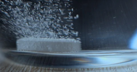 Effervescent tablet falling in water glass slowmotion 4K Stock Footage 93307651