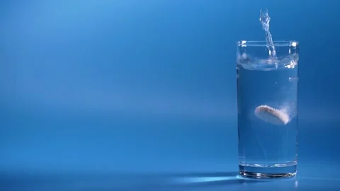 Effervescent Tablet Falling In Water. Pill Falls And Dissolves With Bubbles Vidéo 114971254