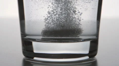 Effervescent tablet falls on a bottom of a clear glass Video stock 61033582