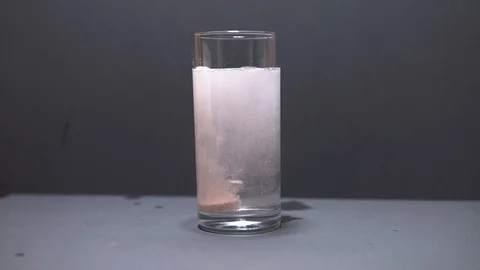 Effervescent tablet falls to the bottom of the glass slow motion Stock Footage 101178236