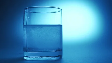 Effervescent tablet falls on a bottom of a glass Stock Footage 124461531