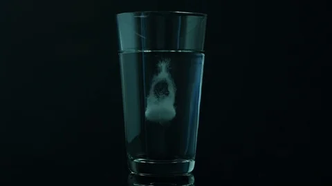 Effervescent tablet falls into a glass Stock Footage 119715580