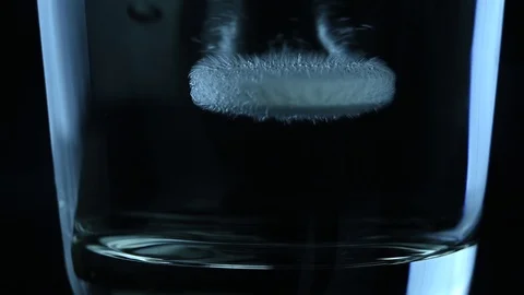 Effervescent tablet falls into a glass Stock Footage 119715870