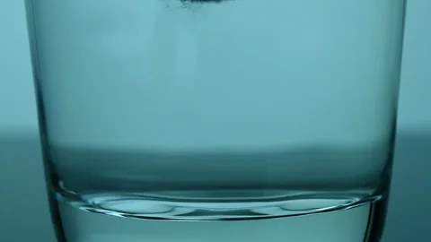 Effervescent tablet falls into a glass Stock Footage 119716335