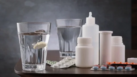 Effervescent tablet vitamin C fall and dissolves in glass with water. Prevent Vídeos de archivo 126991949