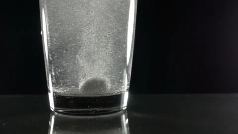 Effervescent tablet in water with bubbles Video stock 92013262