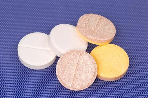 Effervescent tablets on blue surface, close-up in selective focus Stock Photos