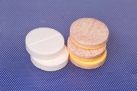 Effervescent tablets on blue surface, close-up in selective focus Stock Photos