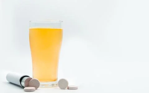 Effervescent tablets tube with blank label and orange effervescent bubbles .. Stock Photos
