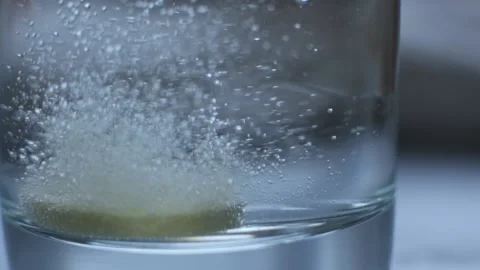 Effervescent vitamin C tablet bubbles in glass of water Video stock 88312625