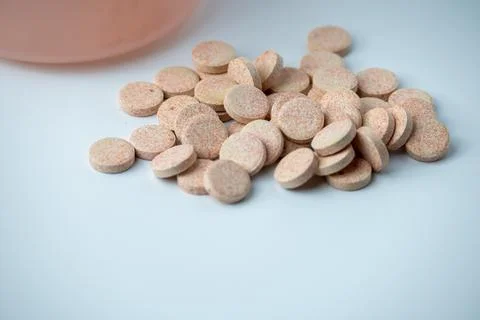 Effervescent Vitamin C Tablets Spilling from Container on White Background Stock Photos