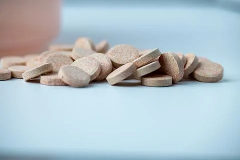 Effervescent Vitamin C Tablets Spilling from Container on White Background Stock Photos