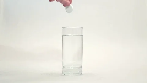 Effervescent white tablet falls in glass water on white background. Fizzy tablet Stock Footage 75898176