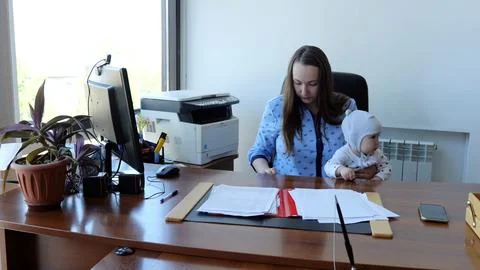 Efficient and caring, a working mother multitasks with her baby at her cozy home Foto stock
