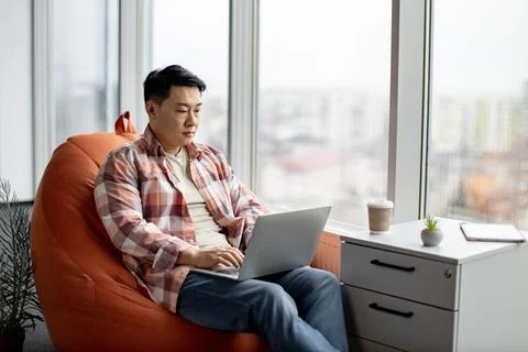 Efficient asian man working on new business plan on laptop Stock Photos
