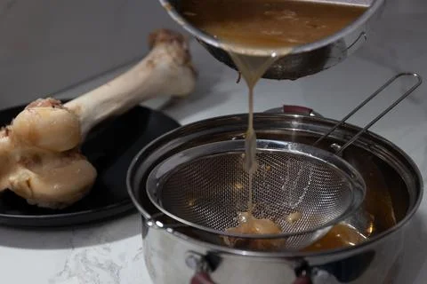 Efficient Bone Broth Extraction: Straining Nutrients from Bones in a Modern.. Stock Photos