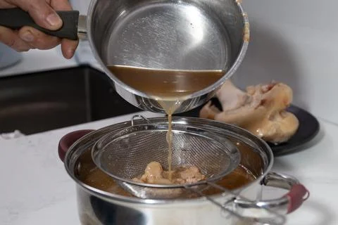Efficient bone broth production: strain and extract nutrients for waste-min.. Stock Photos
