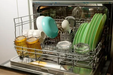 Efficient cleaning process with shiny dishes in the dishwasher Stock Photos