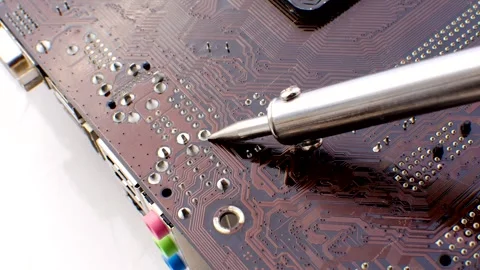 Efficient electronic repairs: a heated soldering iron ready to repair an el.. Stock Footage 260823616