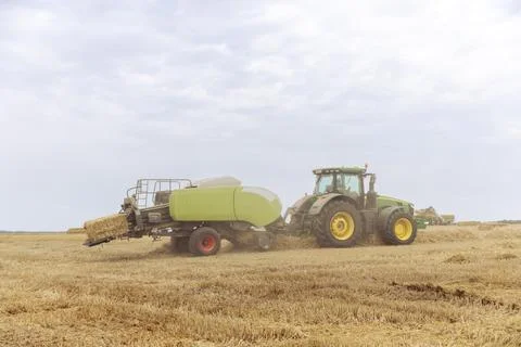 Efficient Harvesting Process: A Green and Yellow Tractor Working Hard in the Foto stock