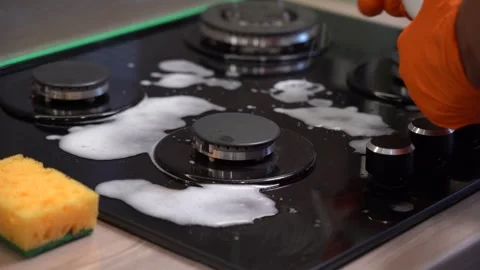 Efficient Kitchen Cleaning: A Focus on the Sparkling Stove as It Receives a Stock Footage 321051324